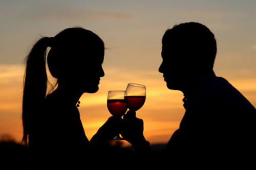 Lovers having a toast at the sunrise, enjoying outdoors.